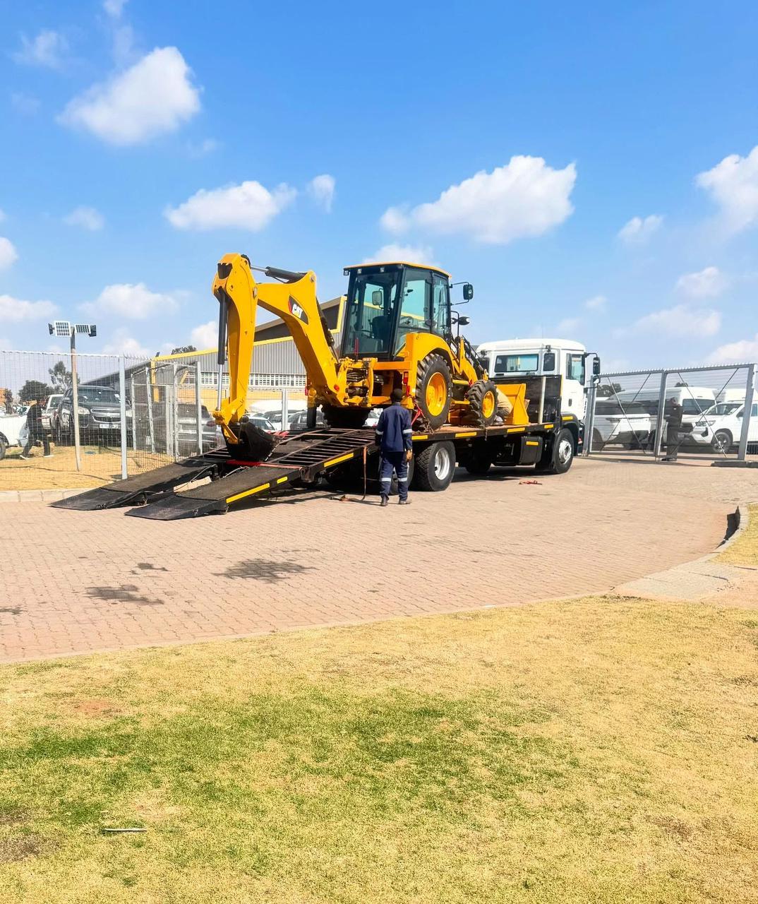 Backhoe loader loaded onto a flatbed truck