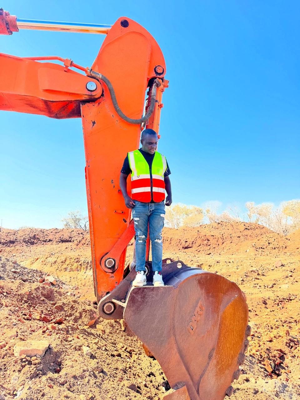 Orange Doosan excavator with crew member on the bucket